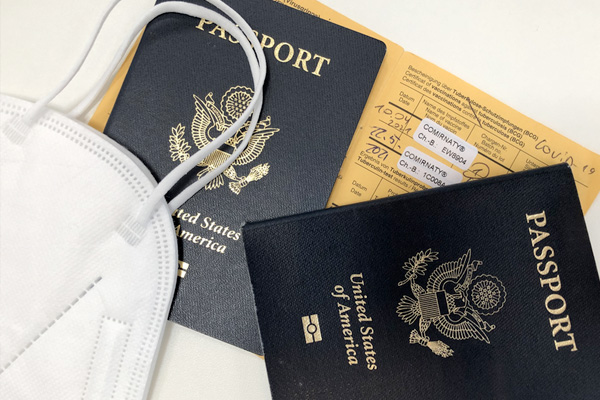 passports and a breathing mask sit on travel documents