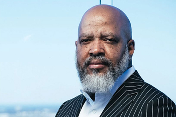 Attorney James Williams poses at window overlooking a skyline.